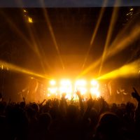 Crowd having party at the concert - Moltitude of people having fun at an event, strobe lights and confetti in the background